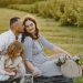 Family enjoying a joyful picnic in a sunny field with their pet cat, capturing a serene and loving moment.